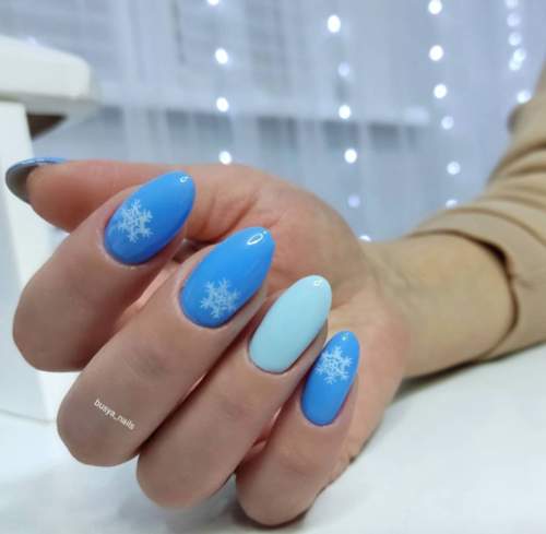 Manucure bleue avec des flocons de neige