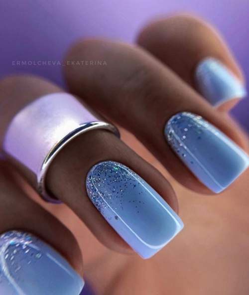 Manucure bleue du Nouvel An avec des étincelles