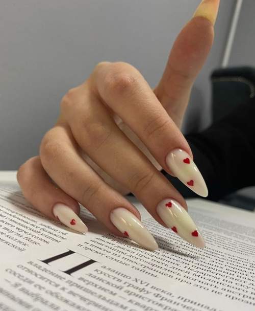 Coeurs rouges sur les ongles longs