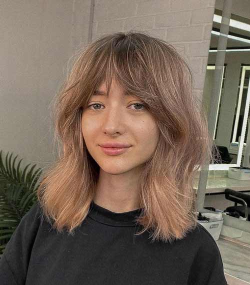 Coupe de cheveux en couches avec une frange