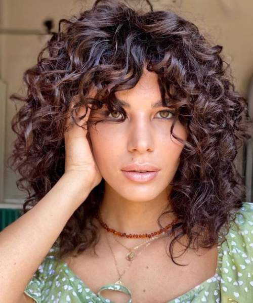 Cheveux bouclés coupés avec une frange 
